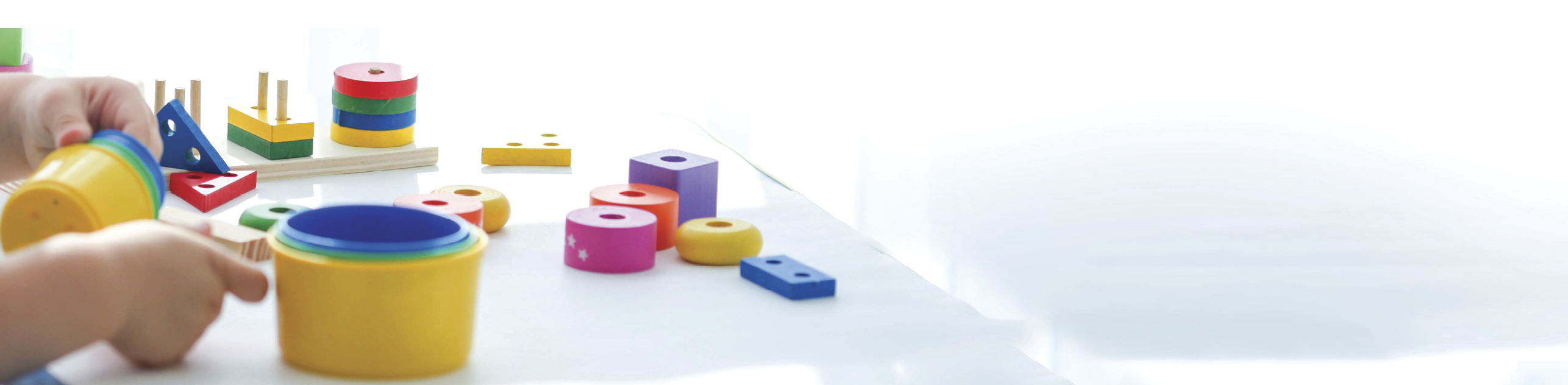 Close-up of a little boy is hand is played with colors toys. Educational logic toys for children. Montessori games for child development. Copy space. Banner