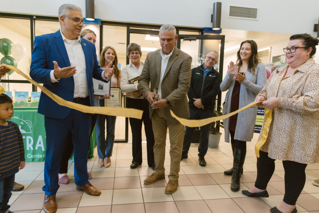 Healthtrax CEO Steve Capezzone cuts a gold ribbon in the East Providence Healthtrax lobby