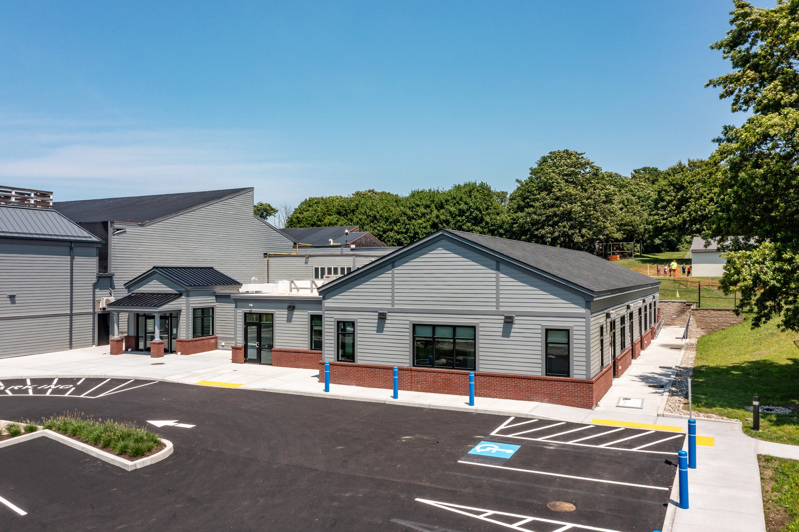 the Newport County YMCA Twice as Nice Preschool entrance and parking lot against a blue sky